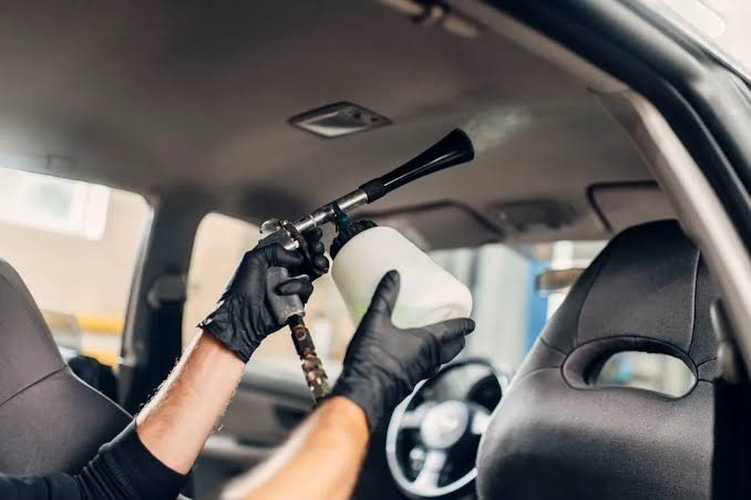 Detailing technician working carefully on a vehicle